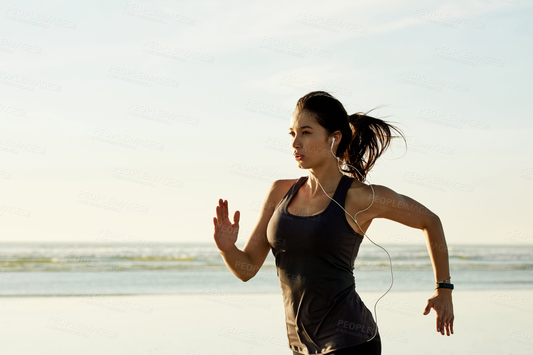 Buy stock photo Exercise, running and girl on beach with earphones, sunrise and commitment to healthy outdoor workout. Music, training and woman at ocean for morning fitness, body wellness and jogging in nature.