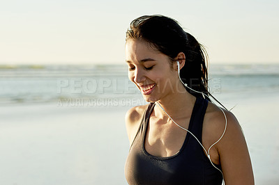 Buy stock photo Fitness music, smile and woman at beach, relax and listening to hip hop album for motivation. Sports, outdoor and girl with earphones for audio, sound or streaming radio for workout podcast at sea