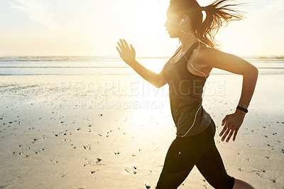 Buy stock photo Woman, beach and runner at sunrise with earphones, training and listen to music with fitness in morning. Girl, person and sound with streaming, subscription or exercise for health with speed in Spain