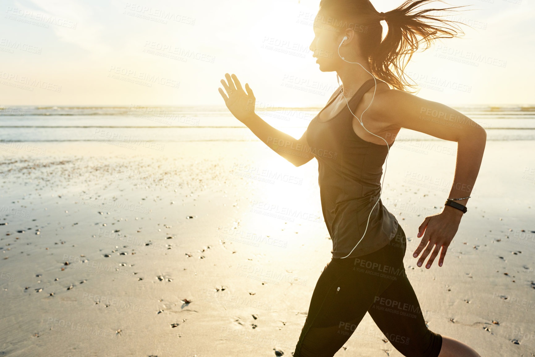 Buy stock photo Woman, beach and runner at sunrise with earphones, training and listen to music with fitness in morning. Girl, person and sound with streaming, subscription or exercise for health with speed in Spain