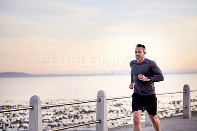Buy stock photo Ocean, running and man with energy, cardio and wellness with workout, exercise and routine. Person, athlete and runner with endurance, morning and fitness with body health, challenge and training