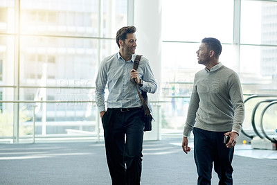 Buy stock photo Business, men and talking with walking in office for work arrival, friendly chat or investment planning. Professional, finance firm and employees with conversation, career discussion or stocks update