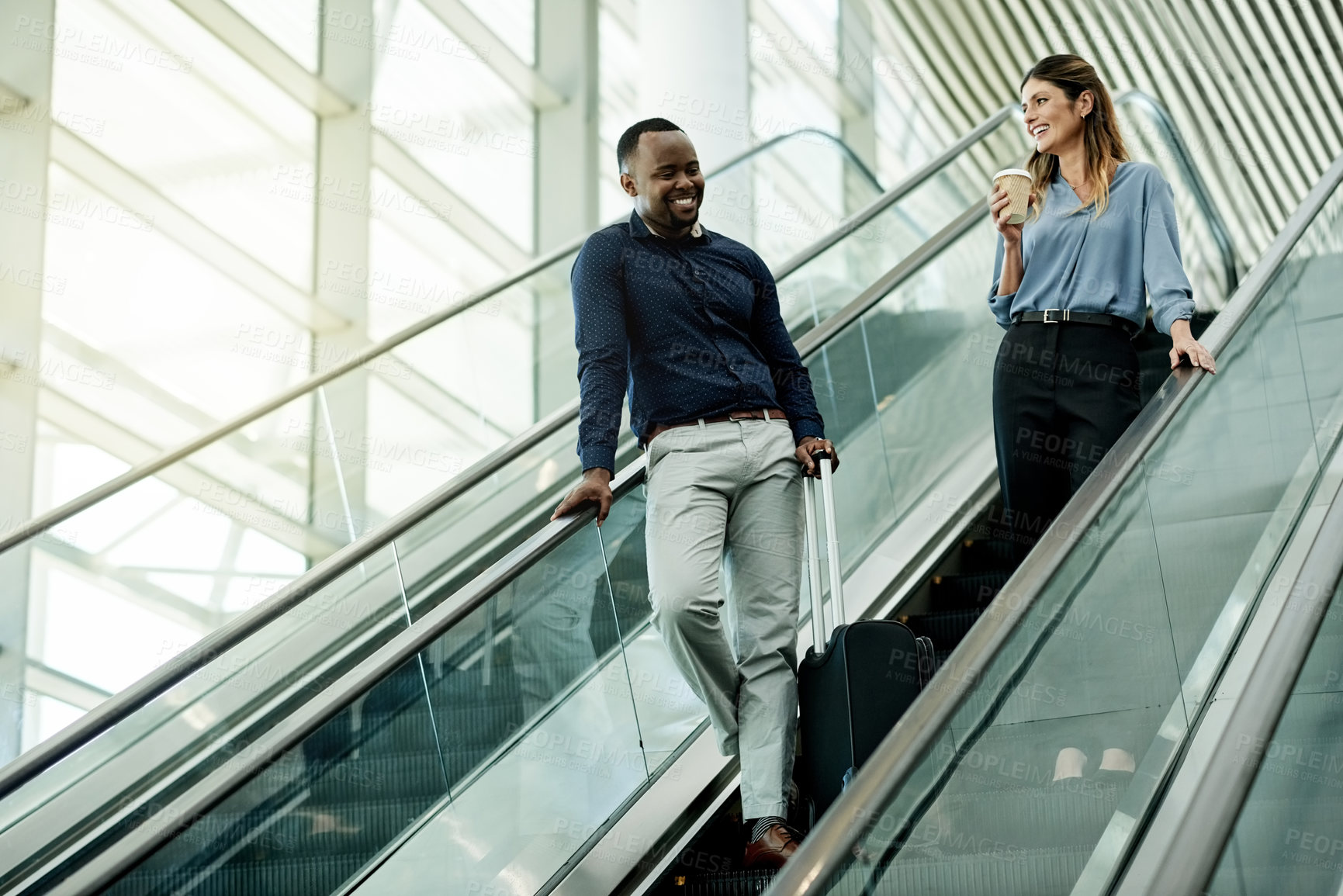 Buy stock photo Escalator, speaking and suitcase with business people in airport together for travel flight. Collaboration, happy and luggage of man employee with woman colleague in lobby for international trip