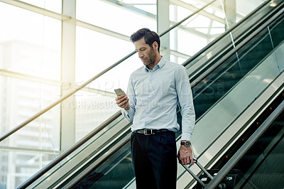 Buy stock photo Escalator, airport and business man with phone for travel, commute and arrival in lobby for trip. Conference, professional and person on electric stairs on smartphone for schedule and flight info