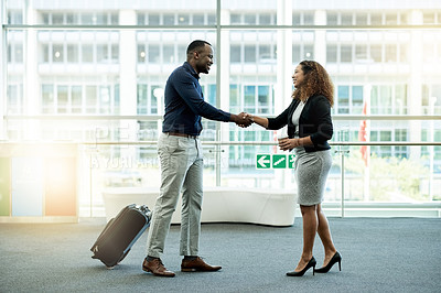 Buy stock photo Handshake, luggage and welcome with business people in airport lobby for friendly greeting or meeting. B2B, smile or travel with employee man and woman shaking hands for international partnership