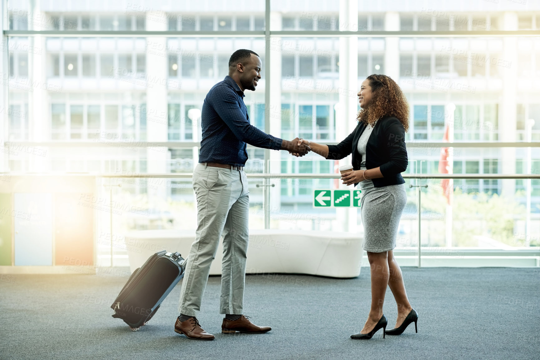 Buy stock photo Handshake, luggage and welcome with business people in airport lobby for friendly greeting or meeting. B2B, smile or travel with employee man and woman shaking hands for international partnership