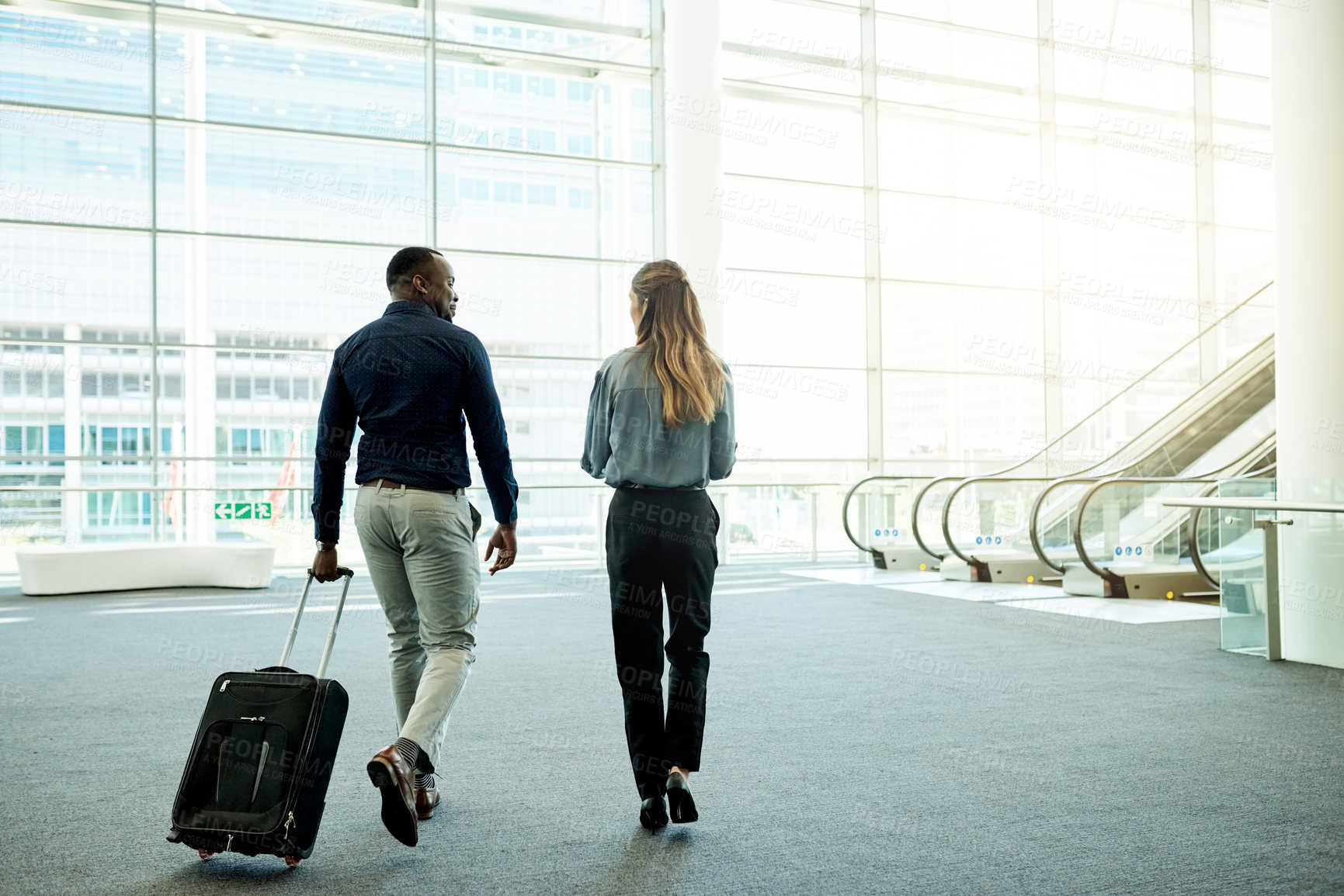 Buy stock photo Walking, airport and back of business people with luggage for travel, commute and arrival in lobby. International trip, conference and man and woman with suitcase for convention, meeting and seminar