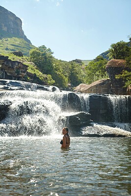 Buy stock photo Waterfall, mountain and portrait of woman swimming for adventure at travel destination in nature. Happy, journey and person relax in water, dam and stream for holiday, vacation and tourism outdoors