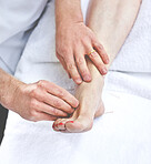 An unrecognizable woman getting needles inserted into her foot during an acupuncture session. Closeup of patient getting alternative therapy for medical treatment
