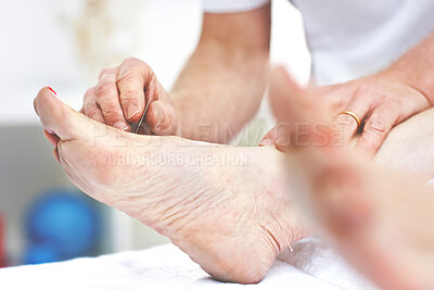 Buy stock photo An unrecognizable woman getting needles inserted into her foot during an acupuncture session. Closeup of patient getting alternative therapy for medical treatment