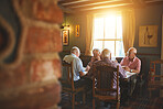 Group of senior men sitting together and enjoying lunch in a pub, elderly friends bonding, eating lunch in a bar