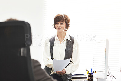 Buy stock photo Two colleagues talking finance in a modern office. A mature businessman and businesswoman working with paperwork, discussing business matters