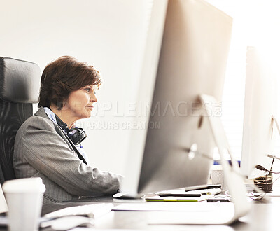 Buy stock photo A businesswoman using a computer in a modern office. A mature female executive working online for business at her desk