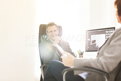 Buy stock photo Two colleagues using a tablet in a modern office. A mature businessman and businesswoman working online with a touchscreen, talking about business matters