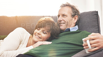 Buy stock photo A mature couple relaxing at home. A happy senior man and woman in love, having a coffee or tea break, sharing a cosy moment on the couch