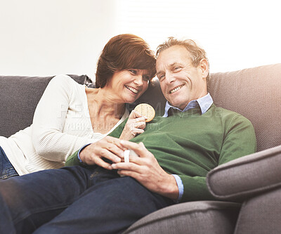 Buy stock photo A mature couple relaxing at home. A happy senior man and woman in love, having a coffee or tea break, sharing a cosy moment on the couch