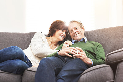 Buy stock photo A mature couple relaxing at home. A happy senior man and woman in love, having a coffee or tea break, sharing a cosy moment on the couch