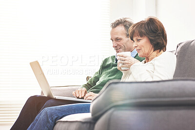 Buy stock photo A mature couple using a laptop, relaxing at home. A happy senior man and woman in love browsing online with a computer on the couch