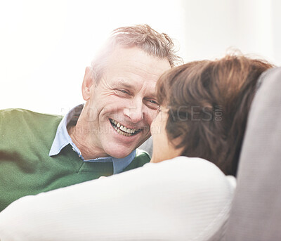 Buy stock photo A mature couple relaxing at home. A happy senior man and woman in love sharing a romantic moment on the couch