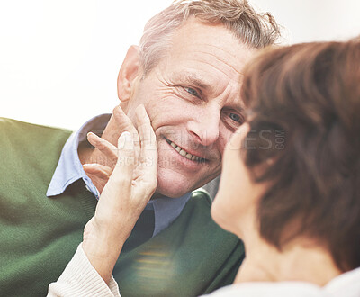 Buy stock photo A mature couple relaxing at home. A happy senior man and woman in love sharing a romantic moment on the couch