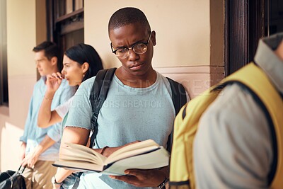 Buy stock photo University, education and black man reading a book in the campus hallway waiting for class. Focus, learning and African male student studying with a textbook in the corridor before a test at college.