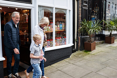 Buy stock photo Man, woman and kid on street by candy shop for sugar snack, shopping or choice for love, care or bonding. Grandparents, boy child and retail store with walk for sweets, product or dessert with family