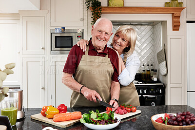 Buy stock photo Happy, portrait and senior couple cooking in a kitchen with care, hug and support at home. Health, food and face of old people with love in a house for brunch, salad or meal prep with raw vegetables