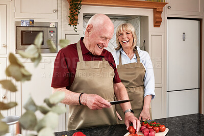 Buy stock photo Happy, laugh and senior couple cooking in a kitchen with care, joke and support at home. Health, food and old people with love in a house for brunch, salad or meal prep with tomatoes or funny humour