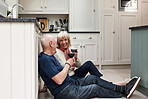 Senior couple, floor and toast wine for celebration, milestone or anniversary with smile, love and bonding in home. Elderly woman, old man and glass for alcohol, relax and cheers for congratulations