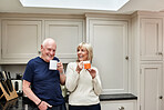 Coffee, laughing and senior couple in kitchen at home together in the morning for conversation, love and healthy connection. Tea, funny and elderly man and woman enjoying drink in mug in retirement.