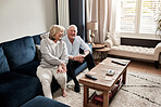 smile, relax and retirement with a senior couple on a sofa in the living room of their home for conversation. Love, funny or laughing with a happy elderly man and woman talking in their apartment