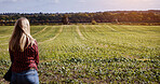 Woman, peace and field with back view in countryside for fresh air, nature and relaxing. Female farmer, casual fashion or clothes on grass, silage or ground for sustainable development in farming