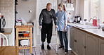 Nurse, senior man in crutches and physiotherapy in home kitchen, medical rehabilitation or recovery. Caregiver, person with a disability walk and support, health and help, healing injury or accident