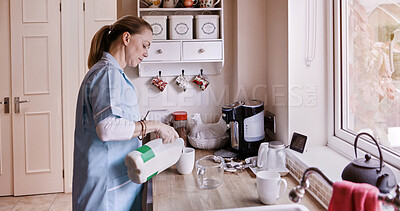 Buy stock photo Morning, tea and a mature woman in the kitchen of her home to prepare a warm beverage in a mug. Relax, wake up and a person in pajamas pouring milk into a cup for coffee while in her apartment