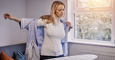 Buy stock photo Woman, wear shirt and iron in home, laundry and housework in living room, apartment or house. Housekeeping service, chores and person with fresh clothes, maid cleaning and domestic work for hygiene
