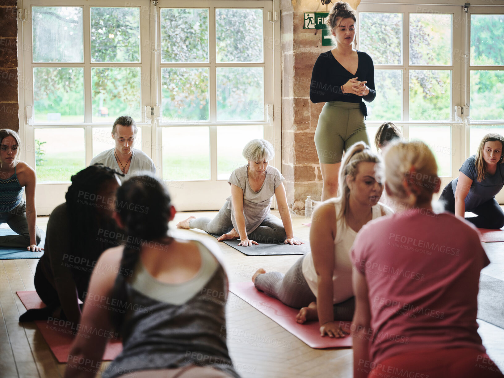 Buy stock photo Yoga, personal trainer and people in class for fitness, exercise and wellness in studio. Health club, stretching and instructor with pilates group for flexibility workout, balance and training