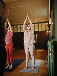Women, yoga or class for stretching arms, breathing or healing in zen studio for body flexibility. Sun salutation, relax or calm people in pilates with mindfulness, support or wellness together 