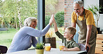 Grandparents, boy and child with high five or happy for celebration, bonding and victory in dining room of home. Family, senior people or grandchild with hand gesture for support, motivation or smile