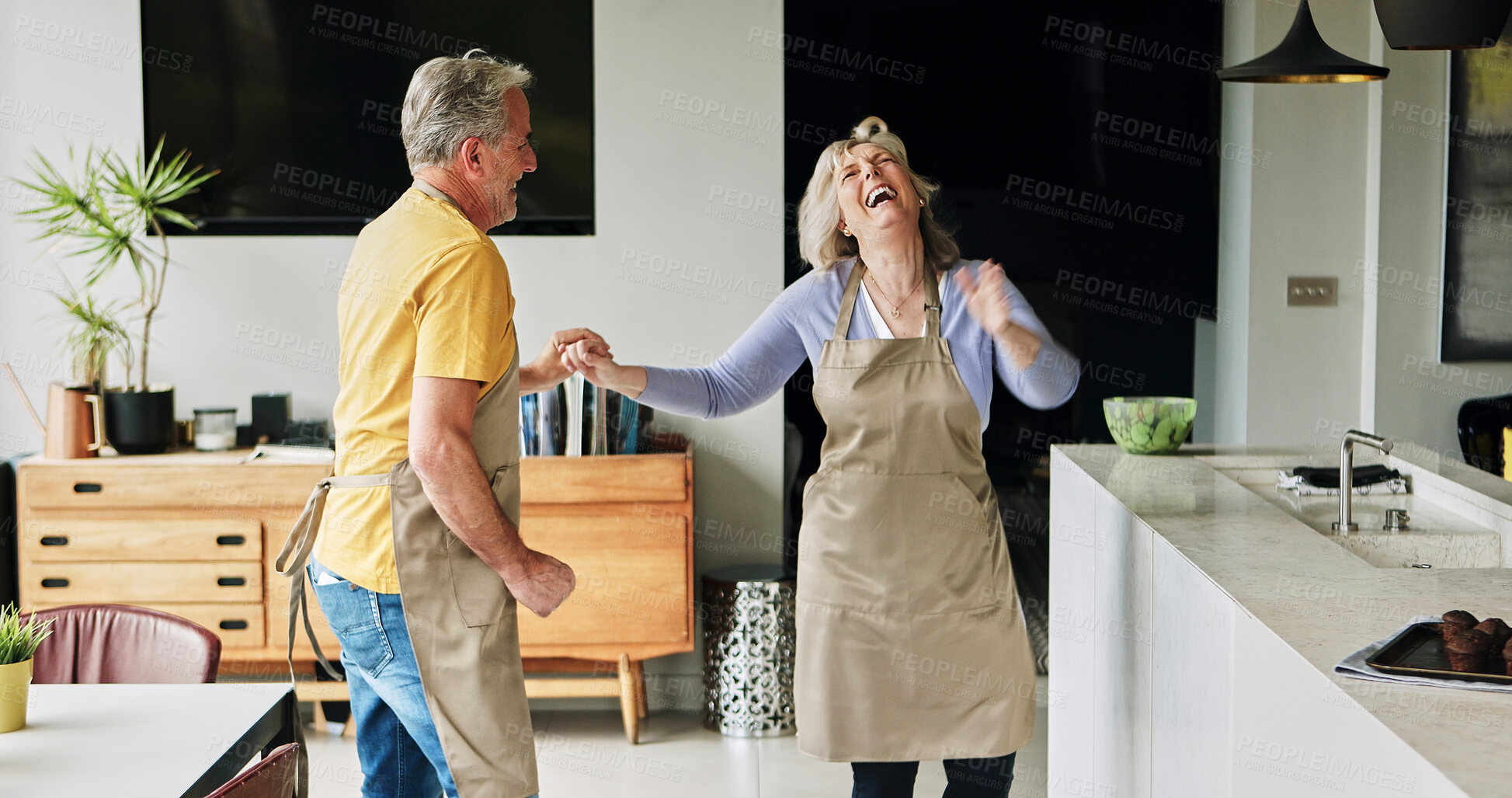 Buy stock photo Senior, couple and dancing in living room or energy with bonding, retirement and marriage in apartment. Elderly, man and woman with dance for laughing, apron and romance with smile in house or home