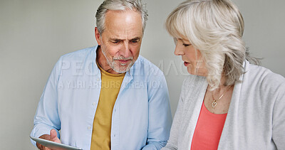 Buy stock photo Tablet, information and senior couple talking together in studio on white background for research. Technology, thinking or online crossword with an elderly man and woman solving an internet challenge
