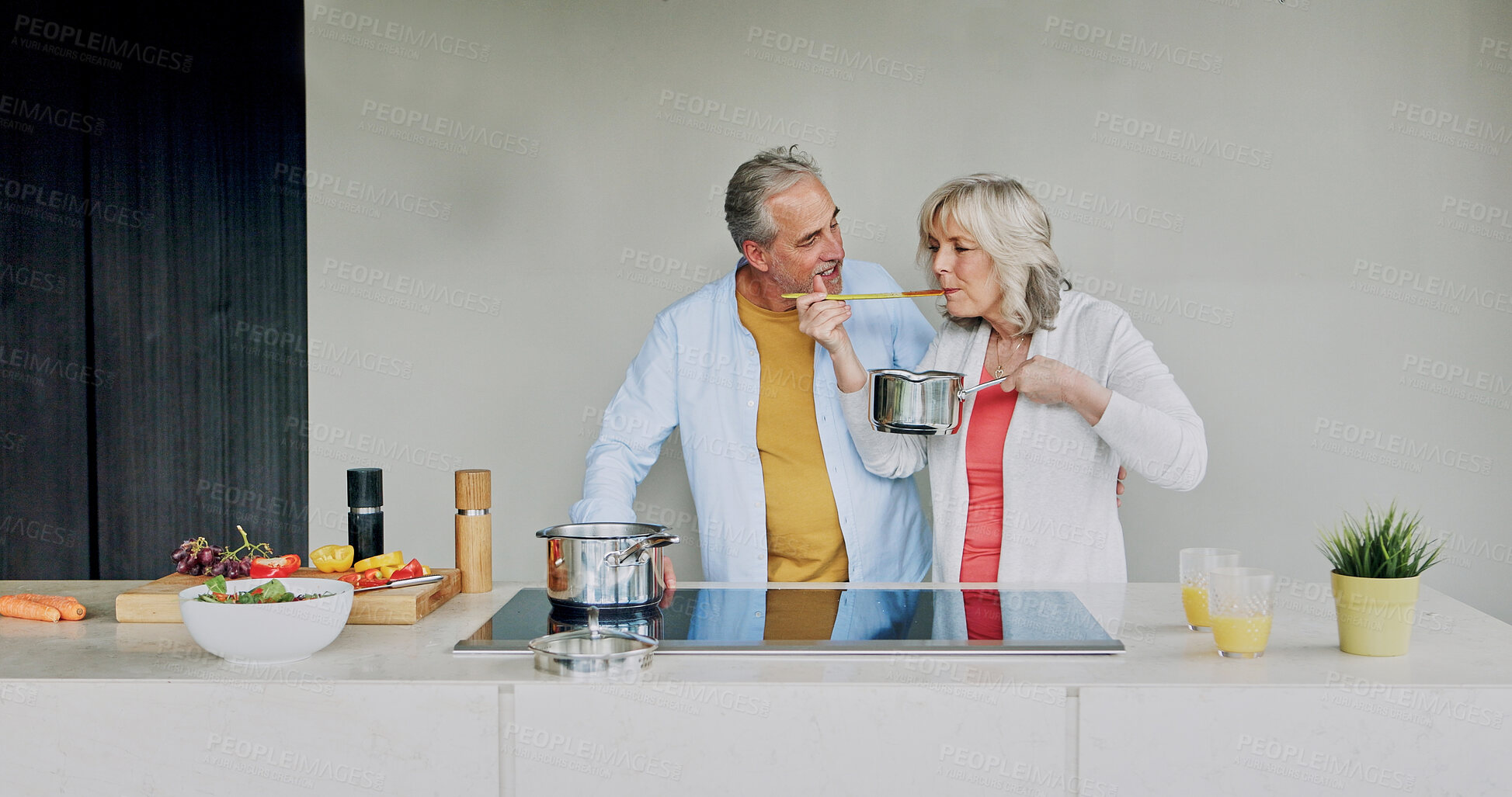Buy stock photo Tasting, cooking and mature couple in home with support, love and meal prep with healthy food in kitchen. Woman, eating and chef at stove with vegetables, diet or nutrition in dinner or lunch