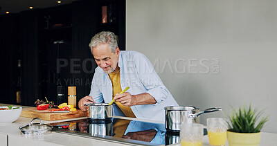Buy stock photo Cooking, kitchen and senior man by stove for lunch, supper and prepare healthy dinner in home. Retirement, chef skills and mature person with natural ingredients, cutting vegetables and eating food