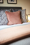 Pillows, fabric and interior patterns in bedroom with duvet, comforter or design for hotel accommodation. Closeup of empty room, house or apartment at resort with stylish cushion, linen or home decor