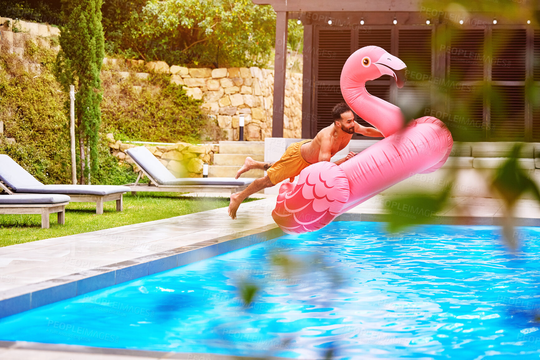 Buy stock photo Man, flamingo and jump into pool for swim, luxury and enjoy the summer at resort. Pink float, male person and dive at water with inflatable toy, excitement and energy on weekend trip for vacation