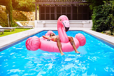 Buy stock photo Relax, weekend and man on inflatable in swimming pool for summer vacation, holiday break or getaway at resort. Outdoor, water and person on flamingo float for sunbathing, travel or comfortable