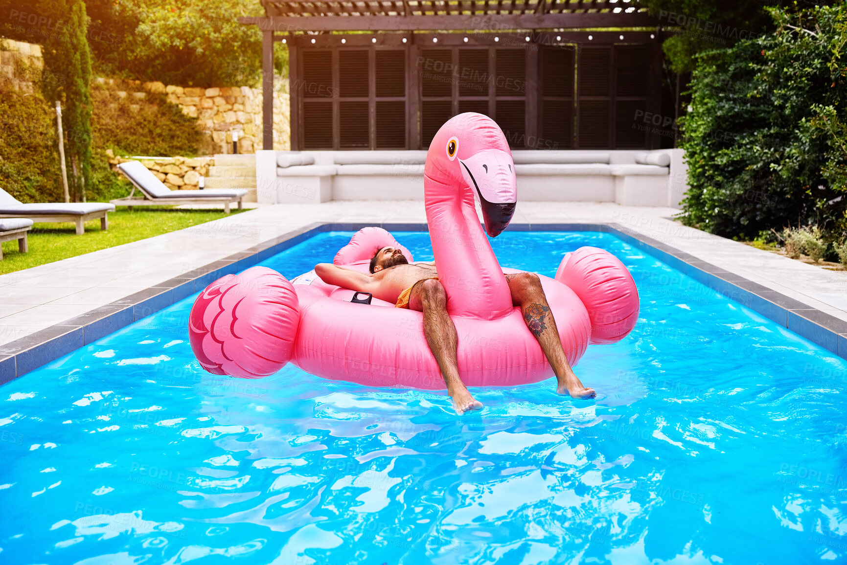 Buy stock photo Relax, weekend and man on inflatable in swimming pool for summer vacation, holiday break or getaway at resort. Outdoor, water and person on flamingo float for sunbathing, travel or comfortable