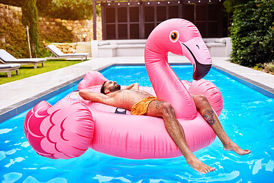 Buy stock photo Float, man and flamingo in swimming pool for holiday, summer and sunshine for vacation. Male person, relax and inflatable bird in water for travel, calm or zen and outdoor for weekend trip to Miami