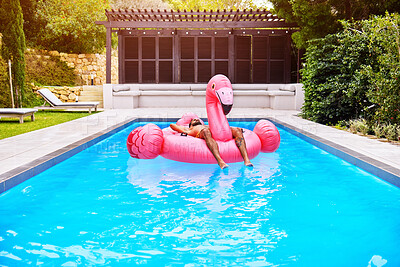 Buy stock photo Man, relax and flamingo in pool in villa for weekend, summer and sunshine for holiday. Male person, sleeping and inflatable bird in water for vacation, calm or zen and floating in backyard of hotel