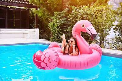 Buy stock photo Happy, woman and relax on flamingo in swimming pool for holiday, summer and sunshine. Female person, influencer and inflatable bird in water for travel, calm or zen and floating for weekend trip 