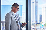 Mature man, business and phone in office building for communication, networking and check schedule. Director, corporate and smartphone in workplace for investment, website or payment of travel flight
